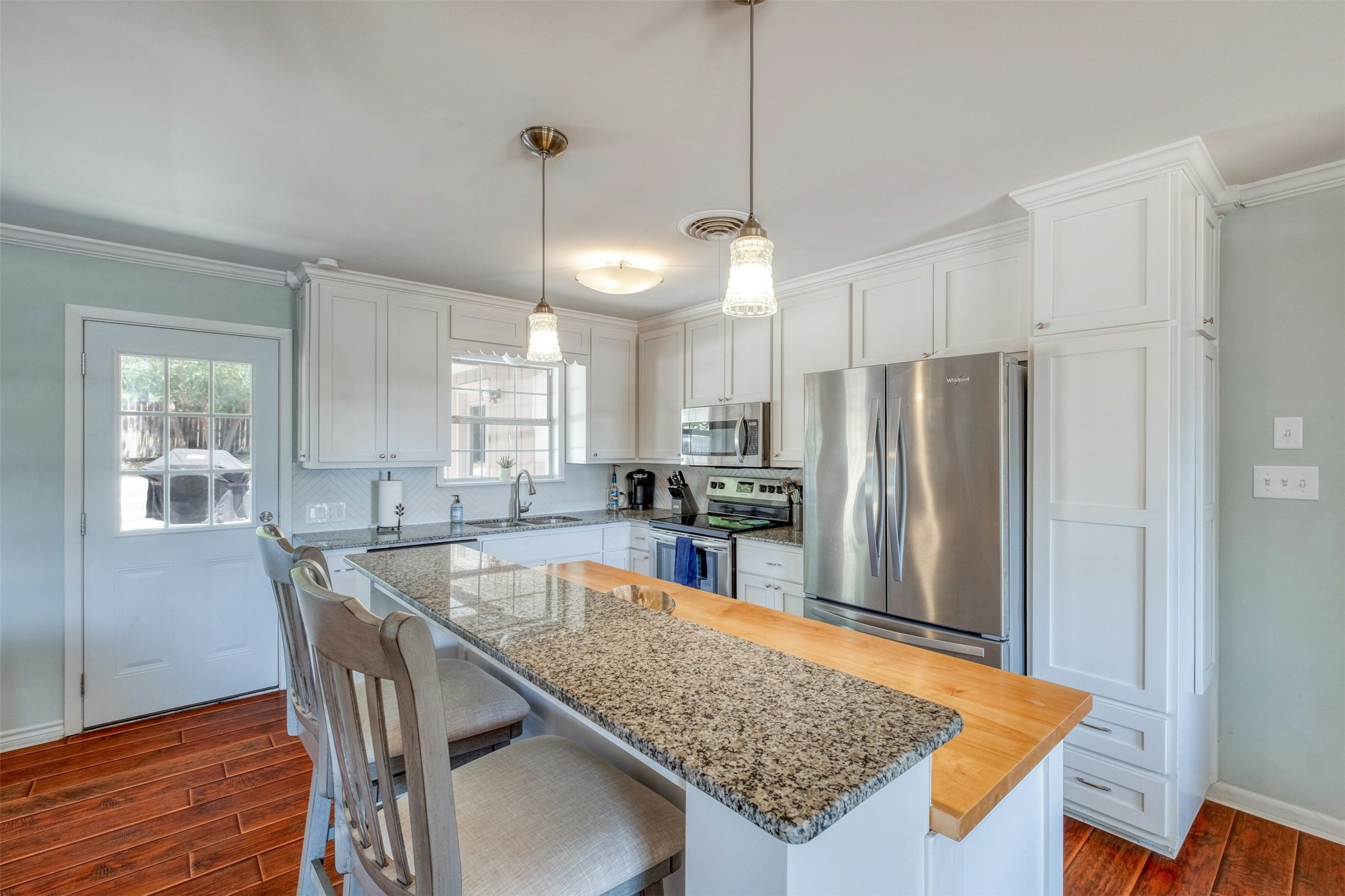 1208 Country Club Road Georgetown, TX 78628 - Photo 11 of 25 a kitchen with stainless steel appliances granite countertop a refrigerator a sink dishwasher a dining table and chairs with wooden floor
