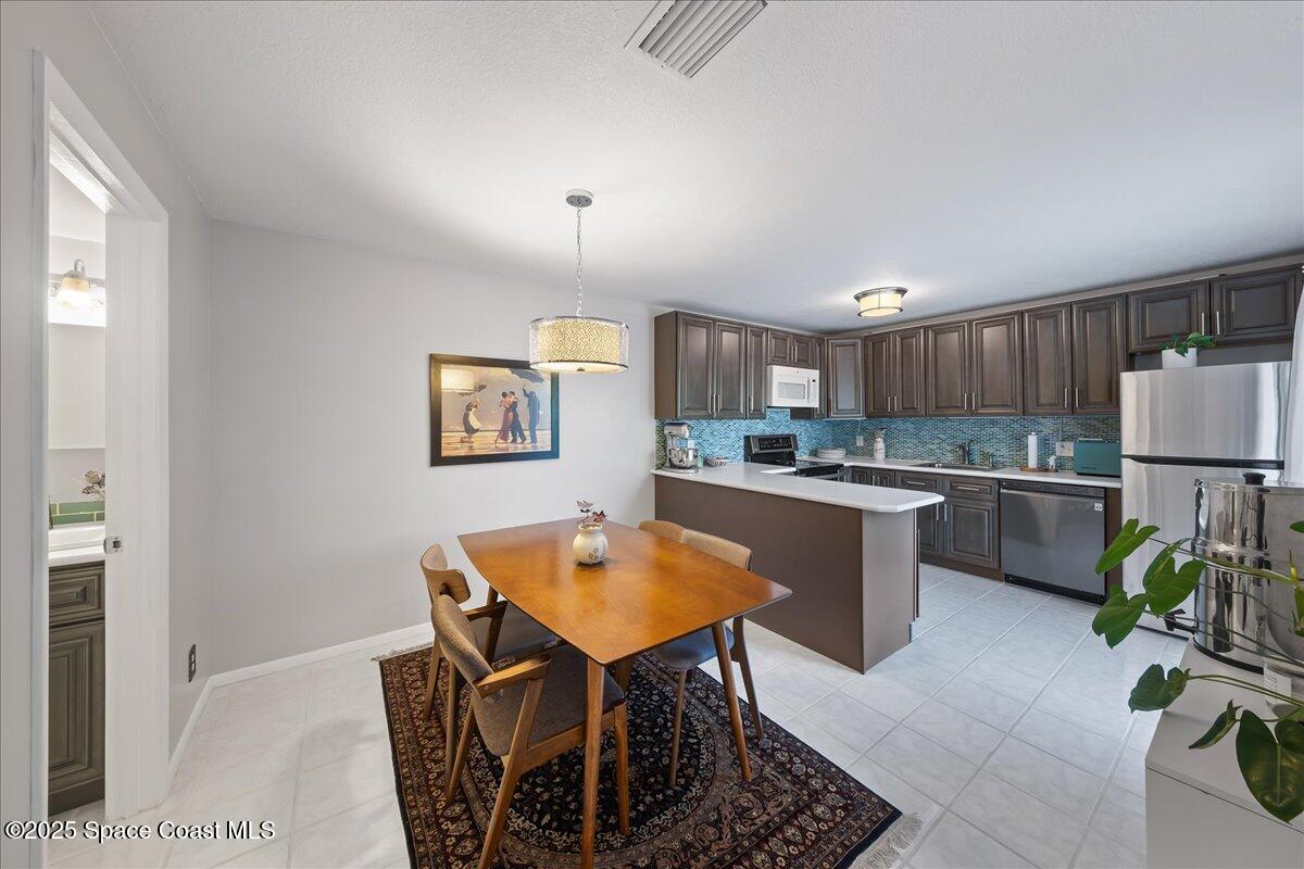 2012 Dan Court Palm Bay, FL 32905 - Photo 10 of 22 a kitchen with a table chairs microwave and cabinets
