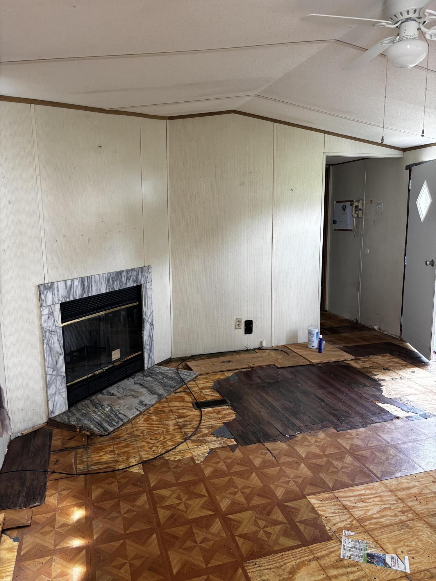 710 Commerce Avenue Iron Gate, VA 24448 - Photo 5 of 6 a view of empty room with a fireplace and wooden floor