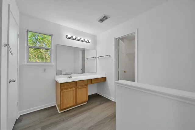 a bathroom with a tub a sink and mirror