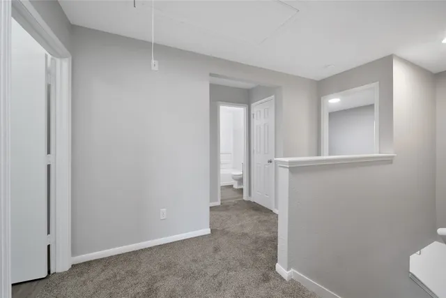 a view of small space with wooden floor and fan