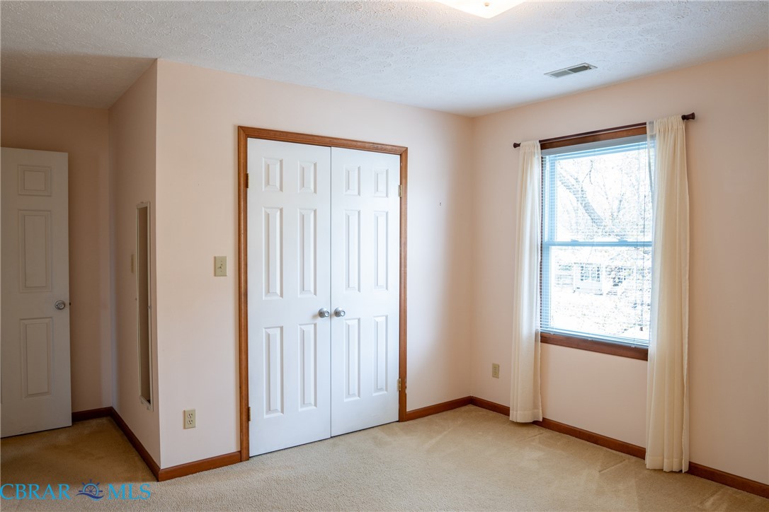 2847 Decatur Drive Hayes, VA 23072 - Photo 23 of 30 Unfurnished bedroom with light colored carpet, a closet, and a textured ceiling