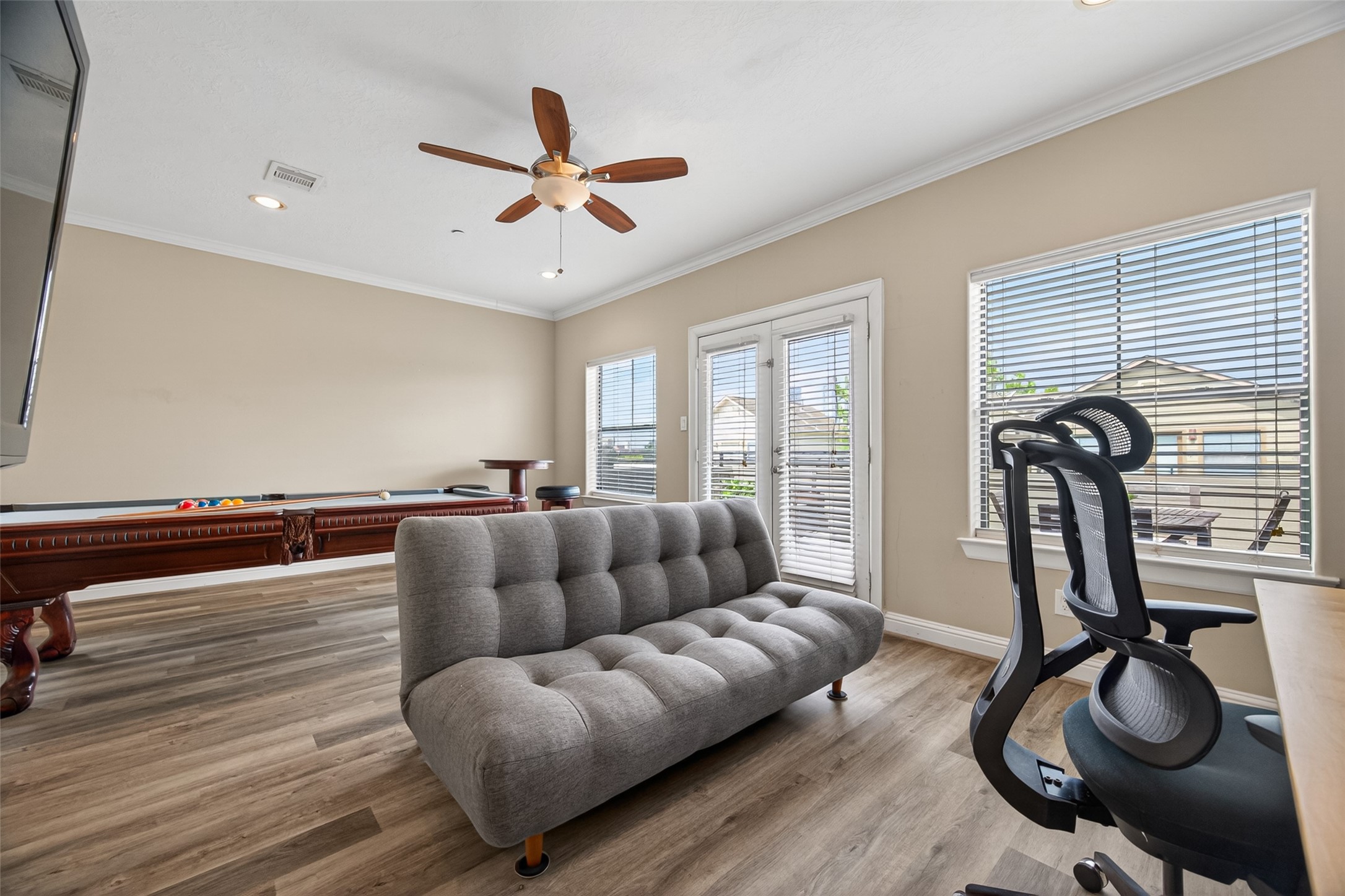 2611 Riverside Drive, Unit C Houston, TX 77004 - Photo 12 of 50 Bright and inviting game room featuring a pool table, sitting area to watch games, and a dedicated workspace/gamer space. Large windows with blinds fill the space with natural light, while a ceiling fan adds comfort. French doors lead to easy access to a stunning rooftop terrace. Perfect for entertaining and relaxing.