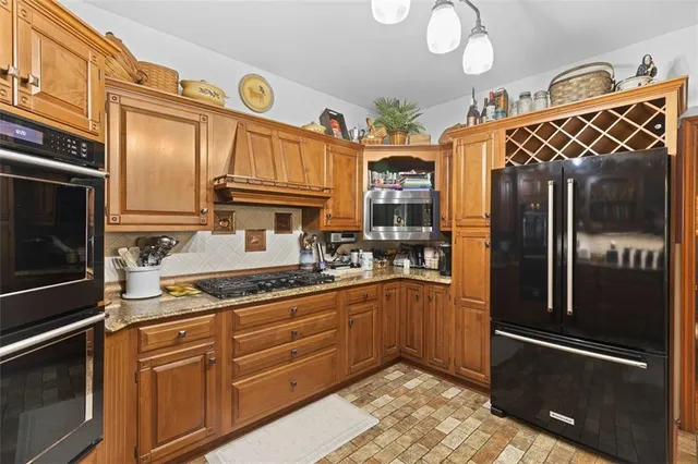 a kitchen with granite countertop stainless steel appliances and wooden cabinets