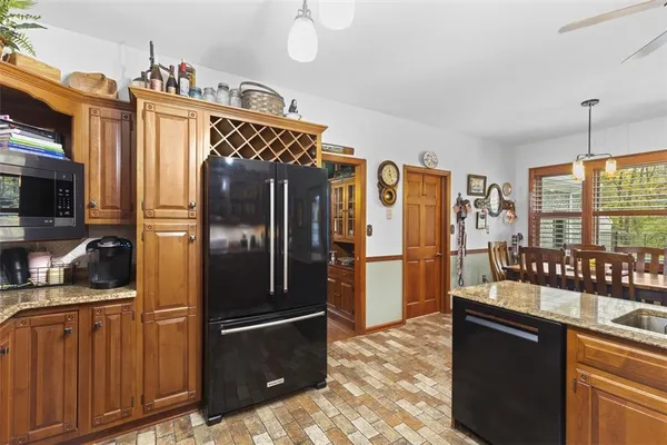 a kitchen with stainless steel appliances granite countertop a refrigerator and a sink