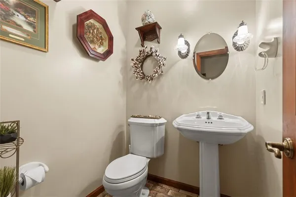 a bathroom with a toilet a sink and a mirror