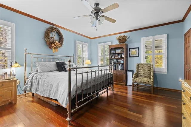 a bedroom with a bed a dresser and paintings on the wall