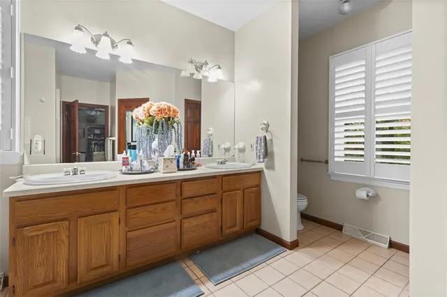 a bathroom with a double vanity sink mirror and bathtub