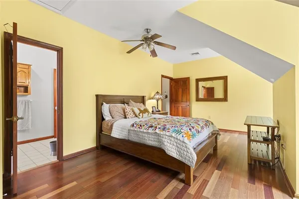 a bedroom with a bed and wooden floor