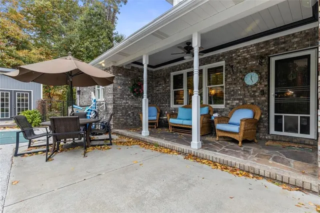 a view of a patio with a table and chairs under an umbrella