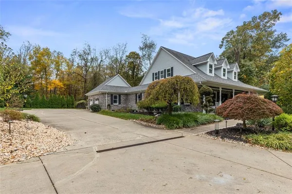 a front view of a house with a yard and trees