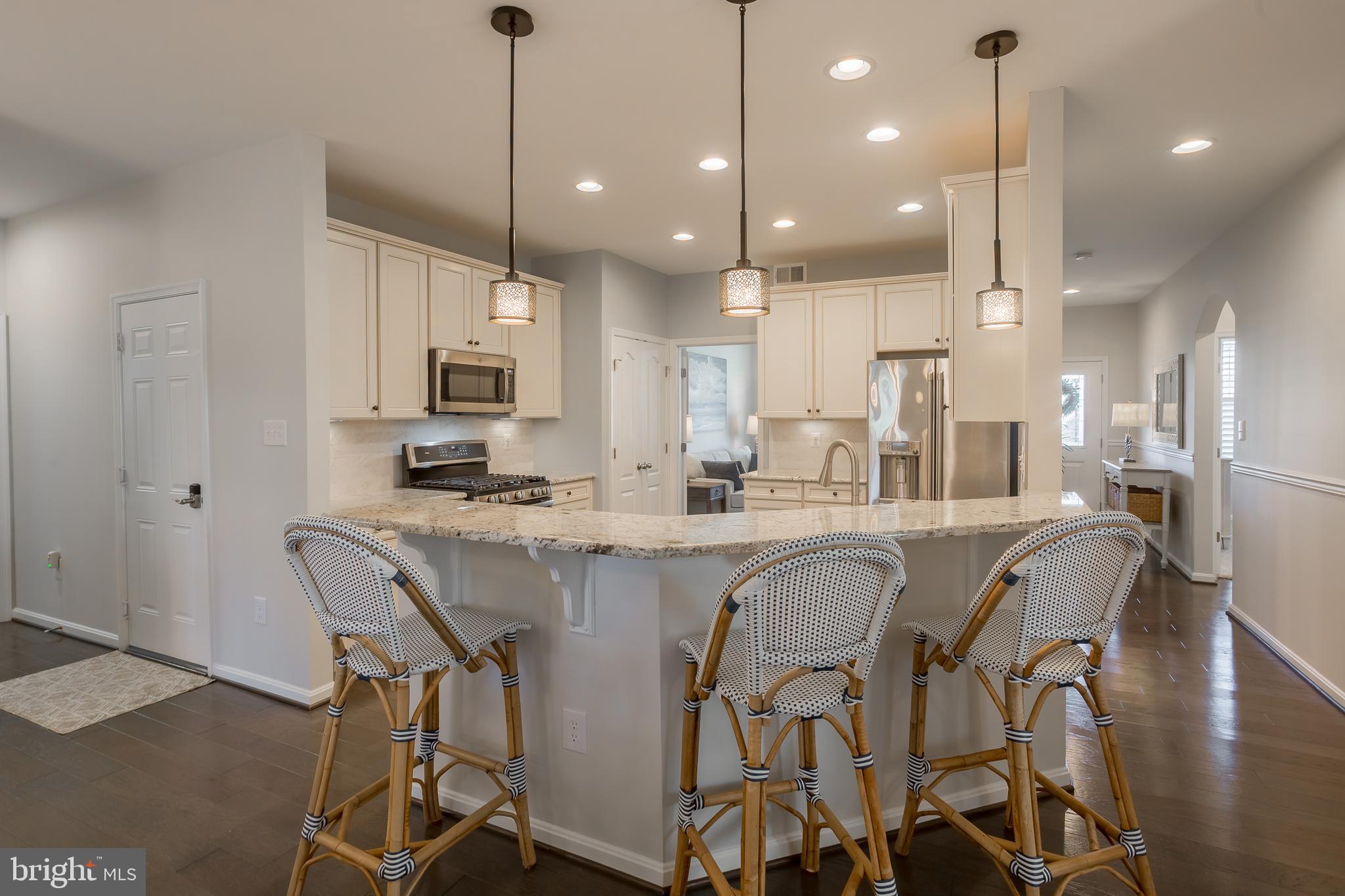 34491 Spring Brook Avenue Lewes, DE 19958 - Photo 11 of 59 a large kitchen with kitchen island stainless steel appliances a stove a table and chairs
