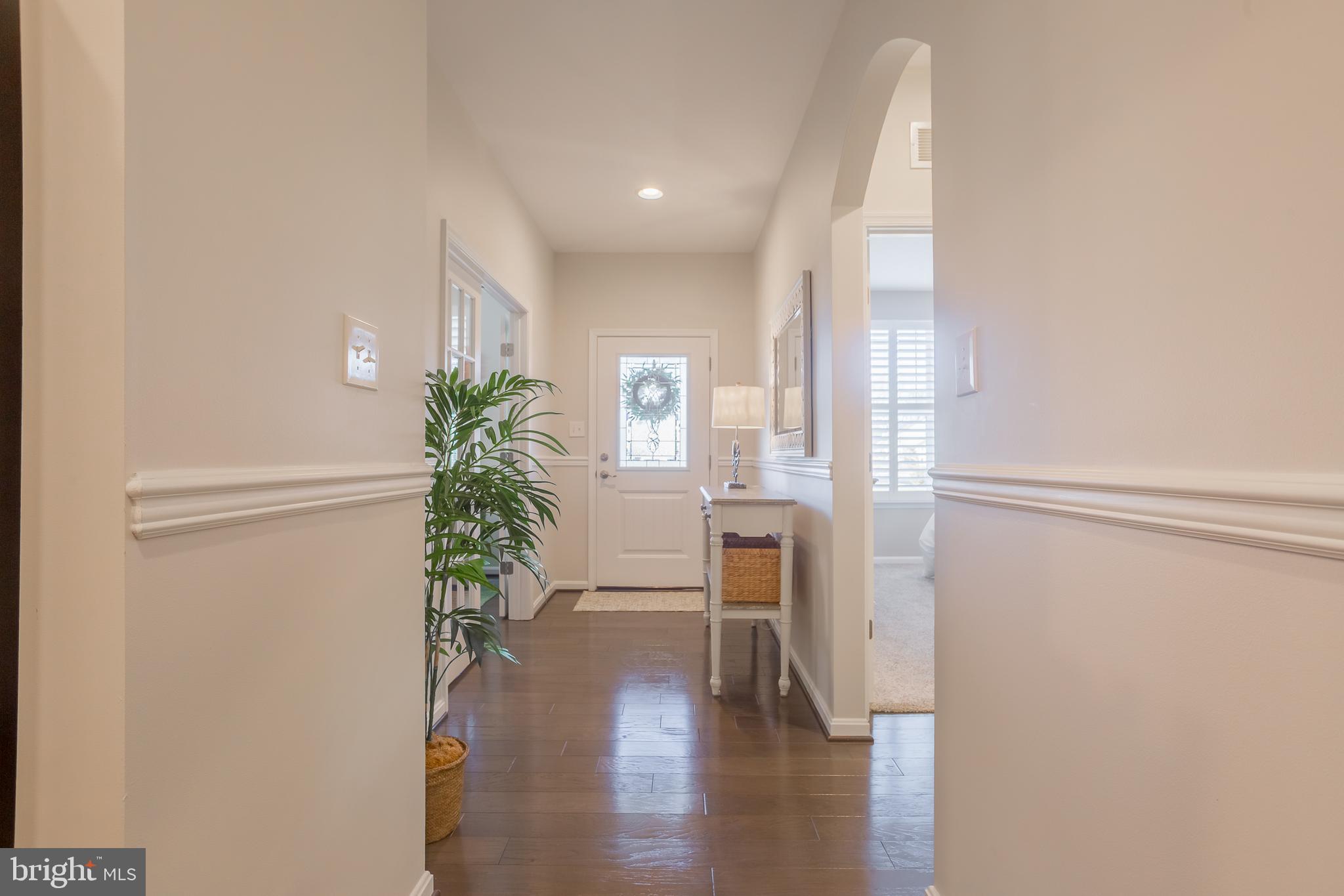 34491 Spring Brook Avenue Lewes, DE 19958 - Photo 2 of 59 a view of a hallway with wooden floor and a potted plant