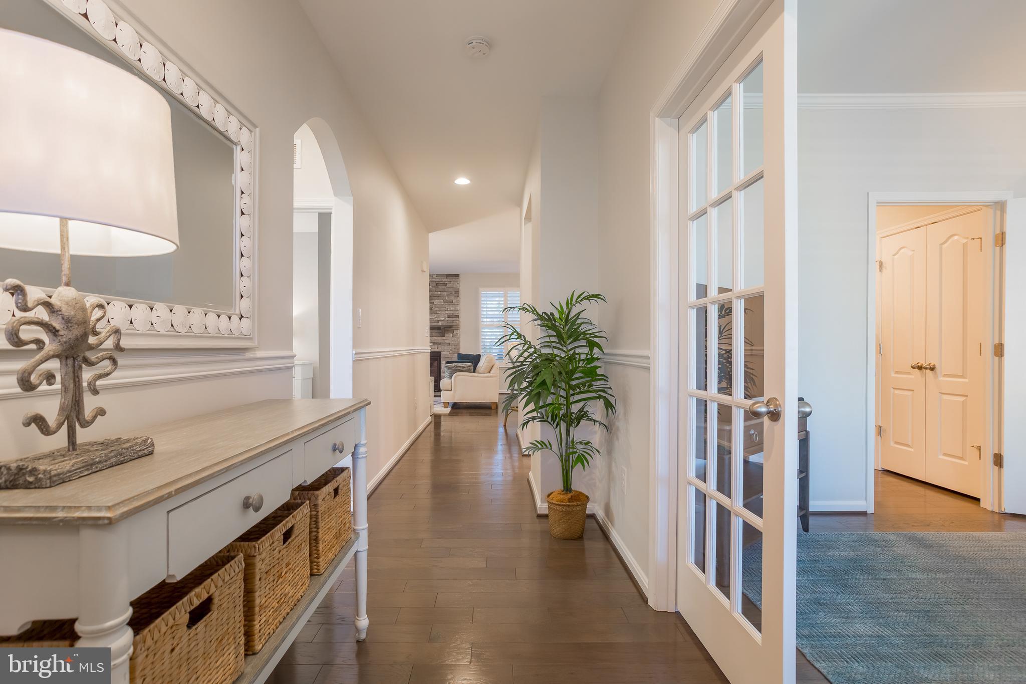 34491 Spring Brook Avenue Lewes, DE 19958 - Photo 3 of 59 a hallway with wooden floor and windows