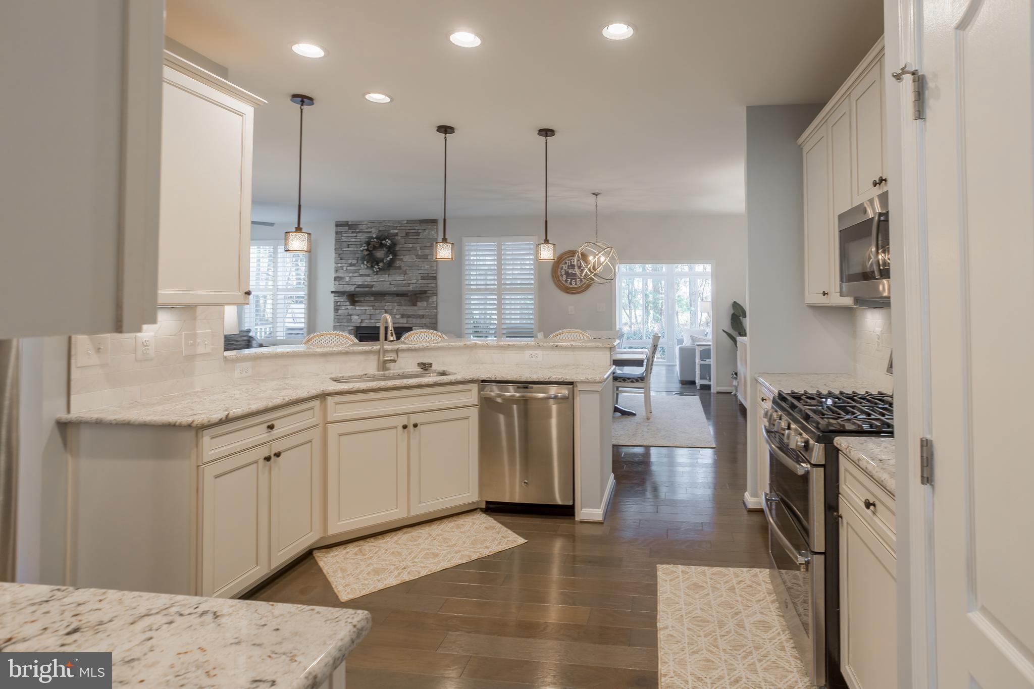 34491 Spring Brook Avenue Lewes, DE 19958 - Photo 7 of 59 a large kitchen with stainless steel appliances kitchen island granite countertop a sink a stove a counter space and cabinets