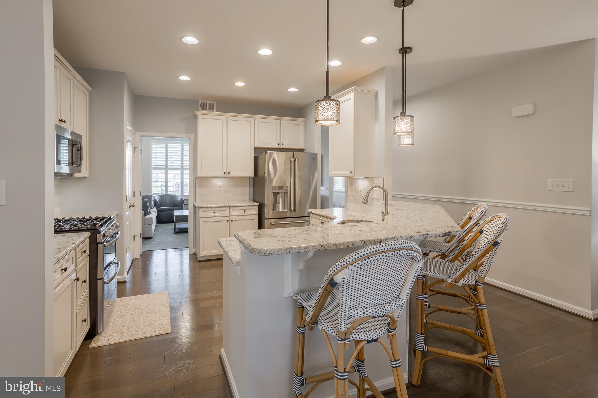 34491 Spring Brook Avenue Lewes, DE 19958 - Photo 10 of 59 a kitchen with stainless steel appliances granite countertop sink refrigerator dining table and chairs
