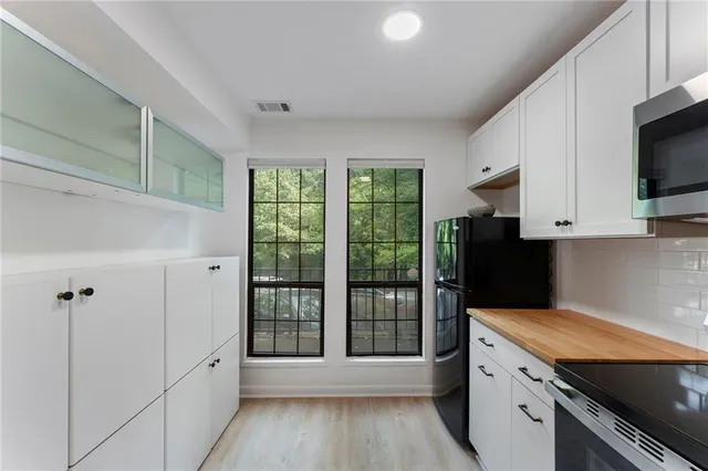 a kitchen with granite countertop a refrigerator and a stove top oven