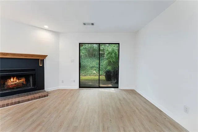 a view of an empty room with a fireplace and a window