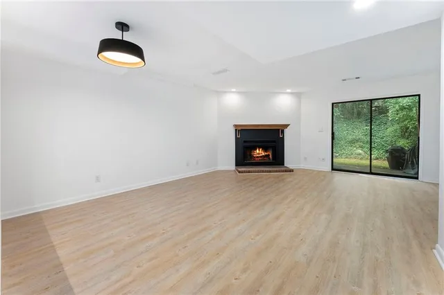 an empty room with windows and fireplace