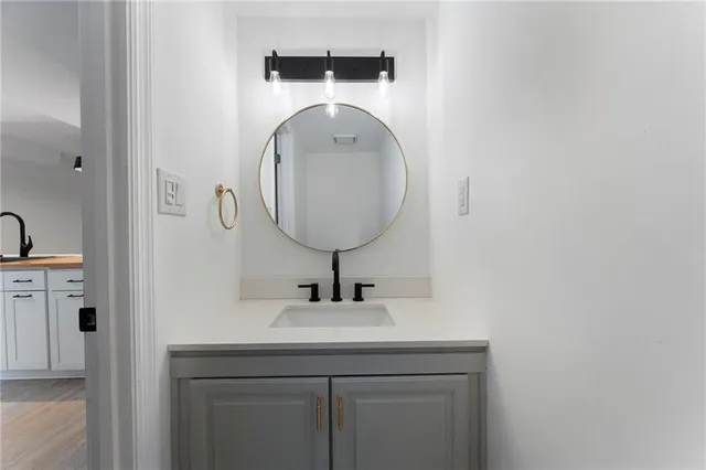 a bathroom with a sink a mirror and vanity