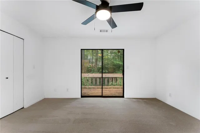 an empty room with chandelier fan