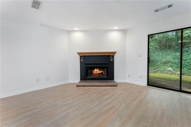 a view of an empty room with a fireplace and a window