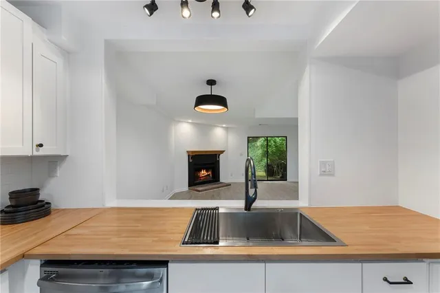 a kitchen with a sink and a stove with wooden floor