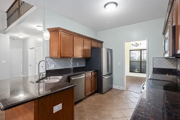 a kitchen with stainless steel appliances granite countertop a sink stove and refrigerator