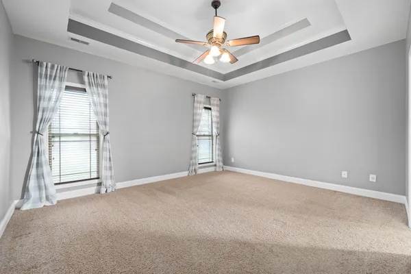 en empty room with windows and ceiling fan