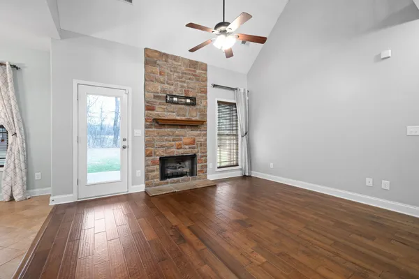 wooden floor fireplace and windows in an empty room