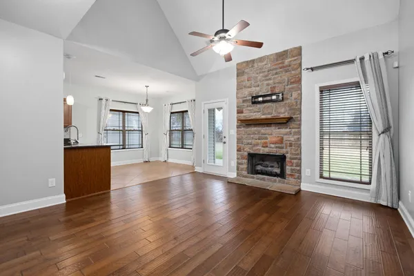 a view of a livingroom with a fireplace wooden floor and window