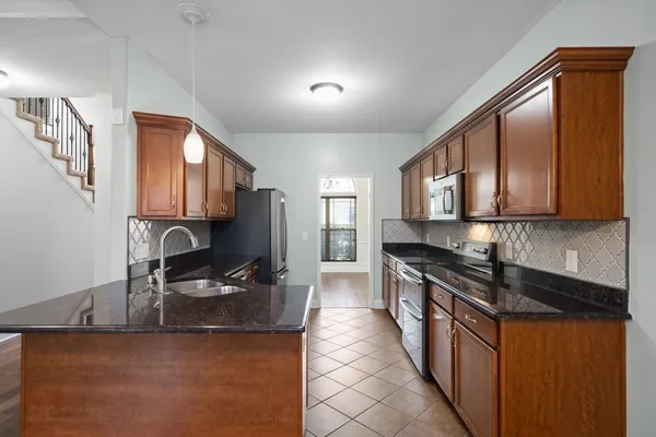 a kitchen with stainless steel appliances granite countertop a sink stove and refrigerator