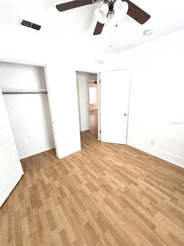 an empty room with a window and wooden floor