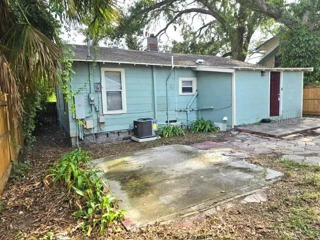 a backyard of a house with large trees and covered with wooden fence