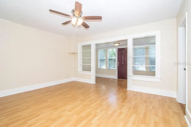 a view of an empty room with a window and a ceiling fan