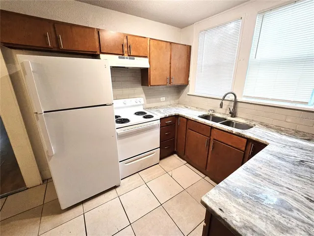 a kitchen with a sink a stove a refrigerator and a sink
