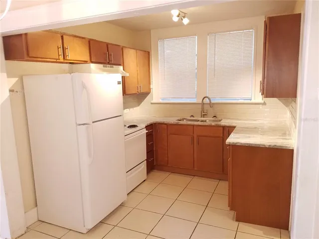 a kitchen with a refrigerator sink stove and cabinets