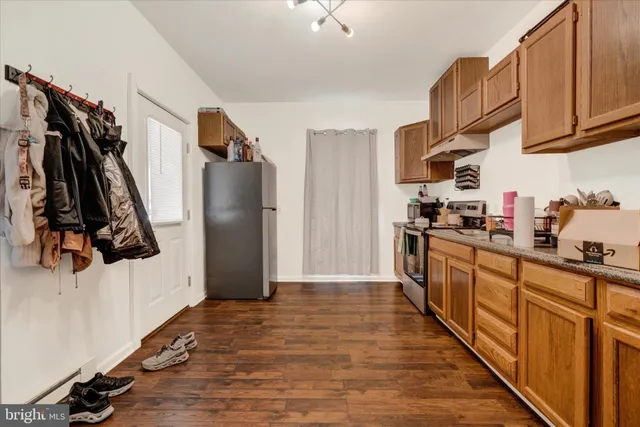 a kitchen with stainless steel appliances granite countertop a refrigerator and a stove top oven