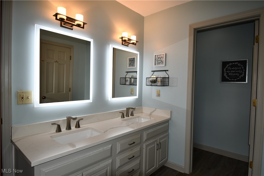 3180 West Calla Road Canfield, OH 44406 - Photo 41 of 49 Bathroom with double vanity, baseboards, a sink, and wood finished floors