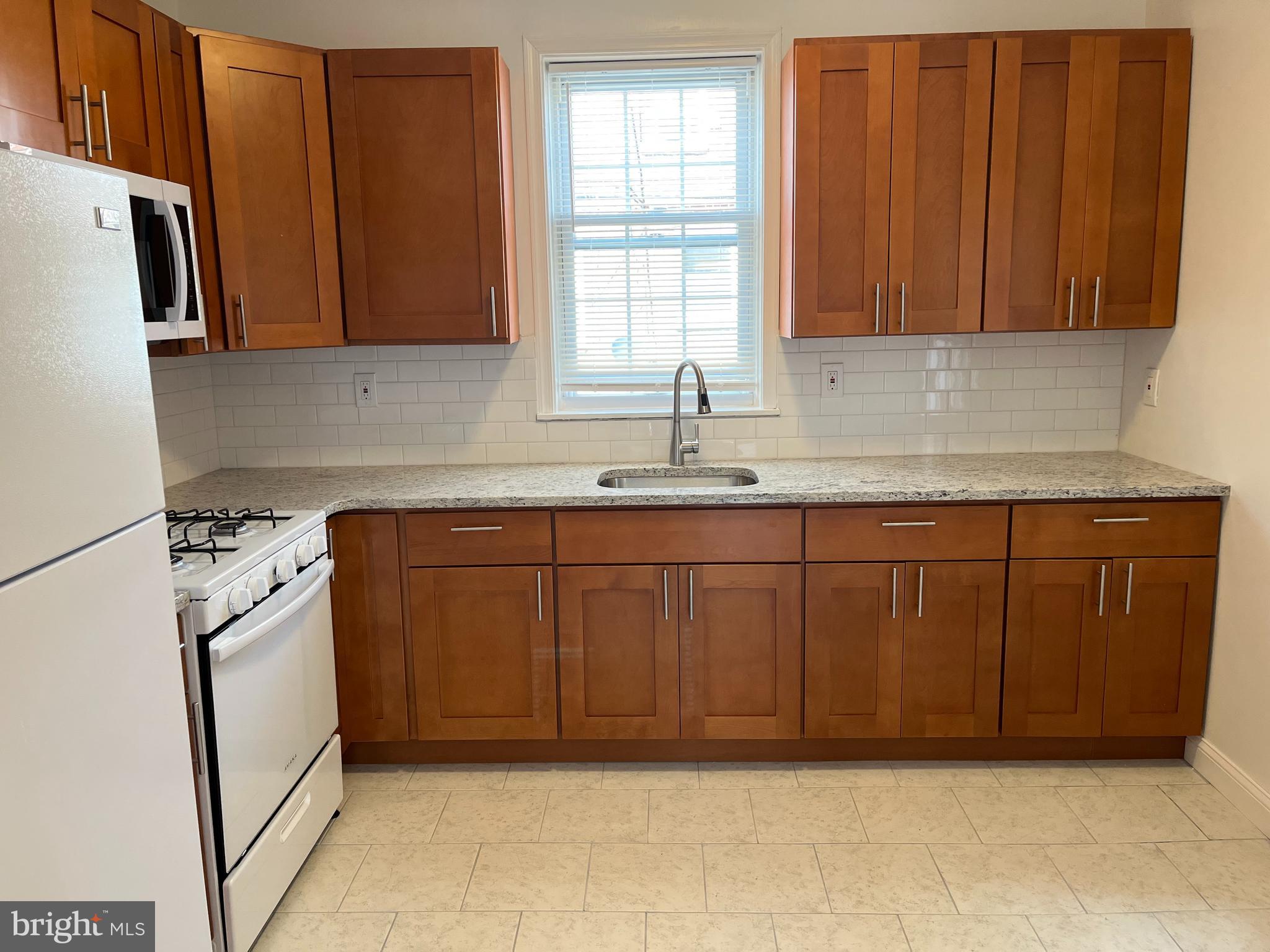 1323 Gilham Street Philadelphia, PA 19111 - Photo 7 of 35 a kitchen with sink cabinets and window