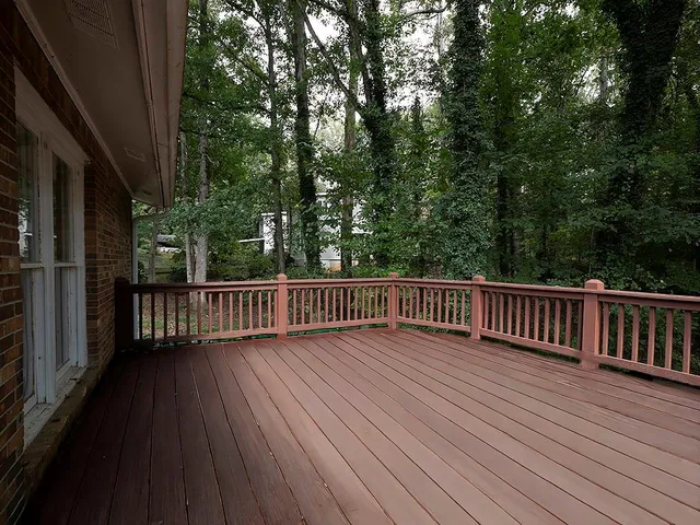 a view of balcony with wooden floor and fence