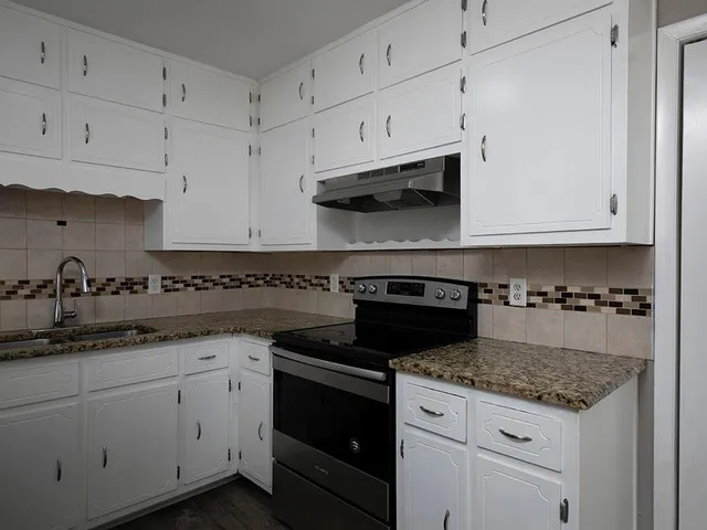 a kitchen with cabinets appliances a sink and a counter