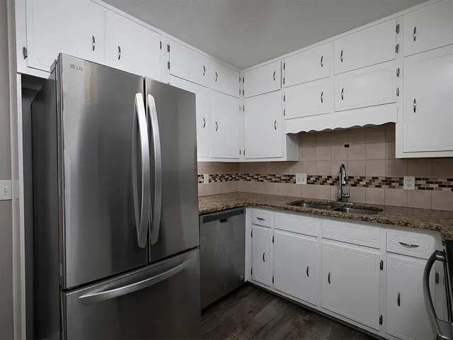 a kitchen with stainless steel appliances a refrigerator sink and cabinets