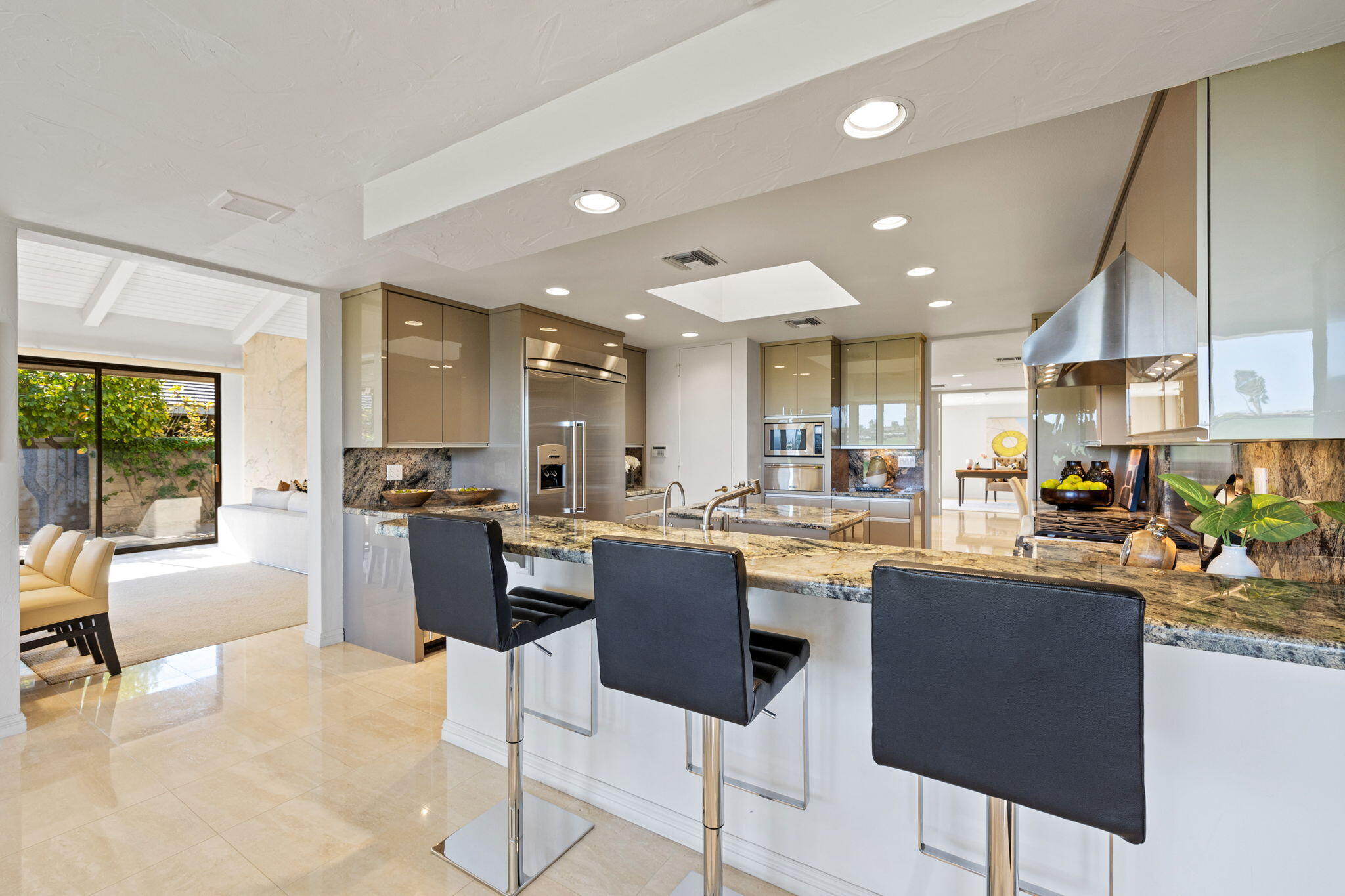 95 Mayfair Drive Rancho Mirage, CA 92270 - Photo 26 of 74 a kitchen with stainless steel appliances kitchen island granite countertop a table and chairs in it
