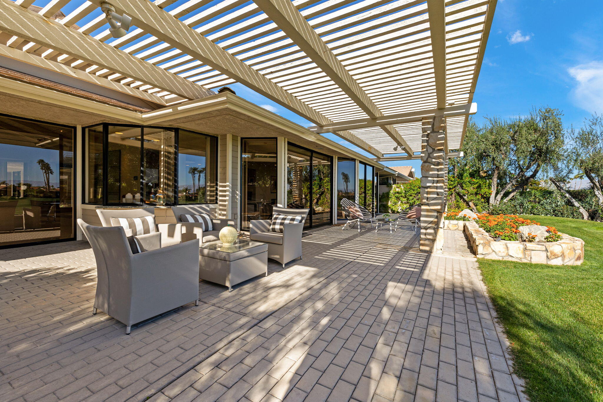95 Mayfair Drive Rancho Mirage, CA 92270 - Photo 57 of 74 a view of a patio with a dining table and chairs with wooden floor and fence