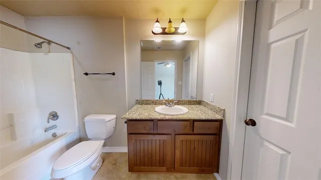 a bathroom with a granite countertop sink toilet a mirror and shower