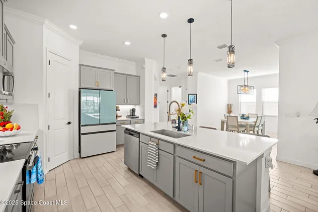 a kitchen with a sink a counter space appliances and cabinets