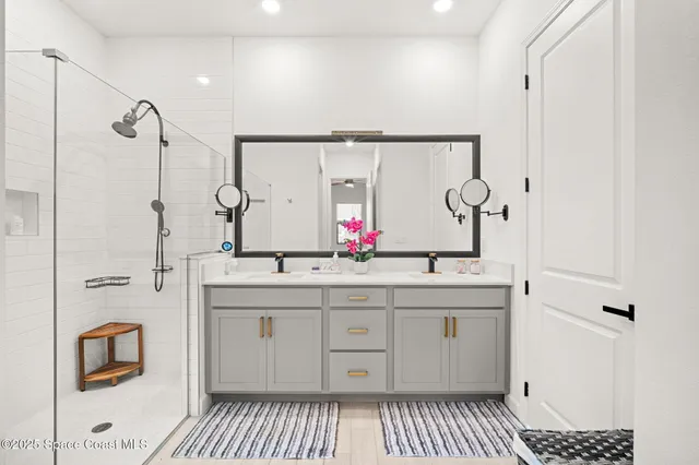 a spacious bathroom with a double vanity sink a mirror and a shower