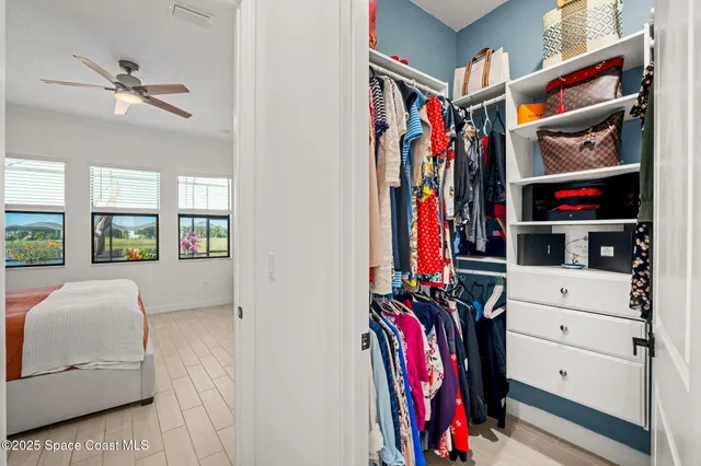 a view of walk in closet with clothes and shoes