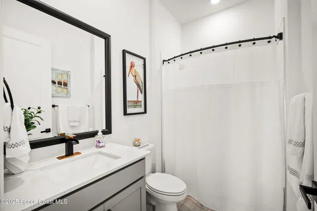 a bathroom with a sink vanity mirror and toilet